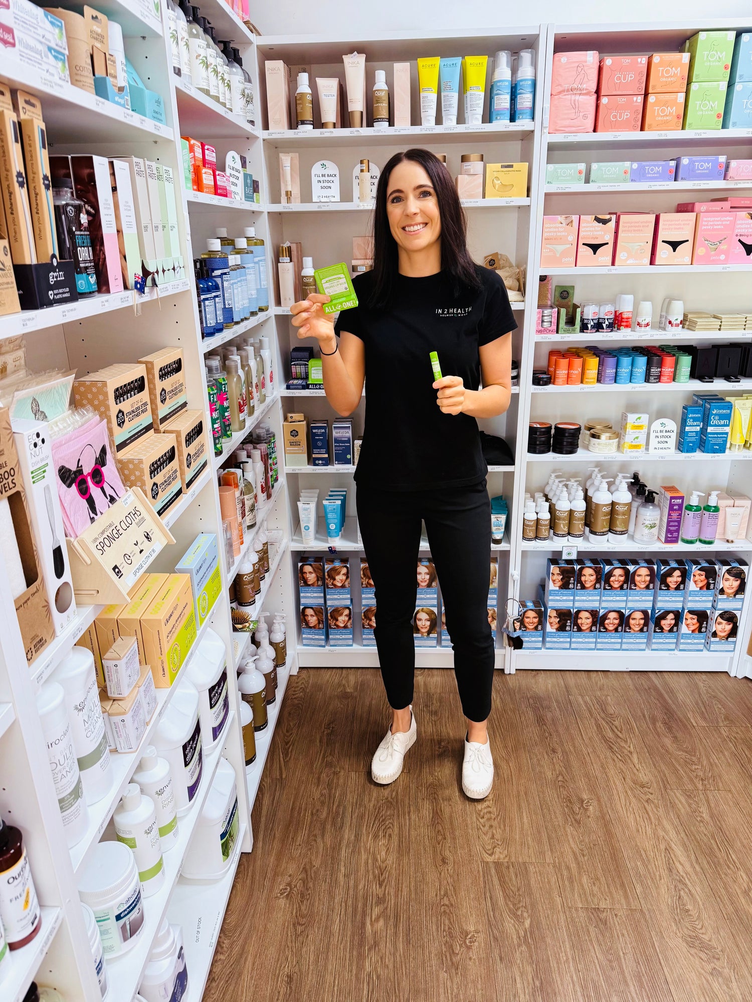 Lady holding lip balm options in Health Shop