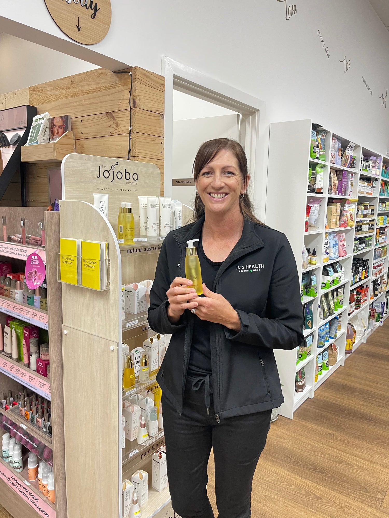 Lady holding jojoba oil in health shop